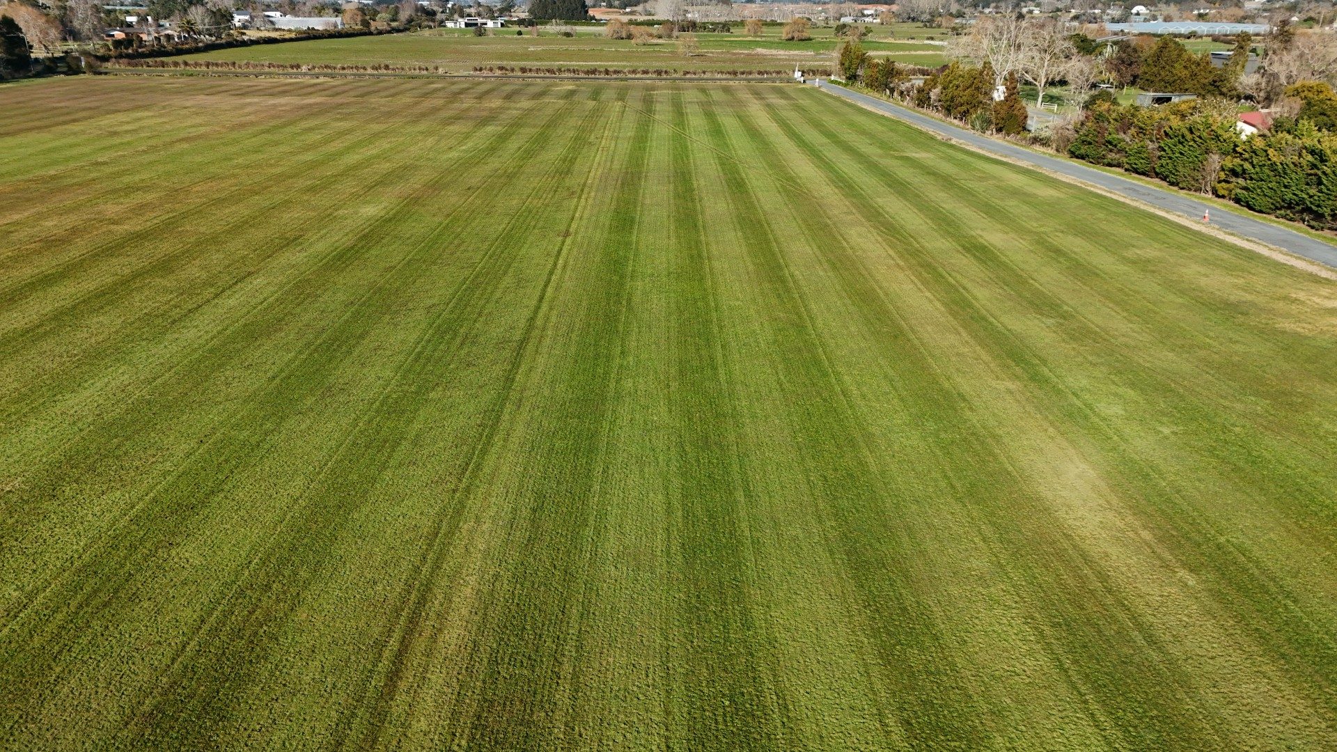 Drone shot of Drury Gliding Club airfield after robotic mowing, showing consistent stripe cutting
