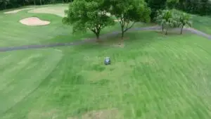 Aerial drone view of the FJD Rough Ranger mowing a fairway at Howick Golf Club near a bunker